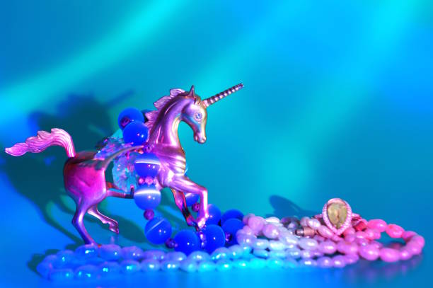 A statuette of a metal unicorn decorated with decorative glass and jewelry. Green background.