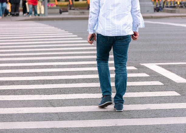 istock A man crosses the road on a white zebra asphalt road 2148937821