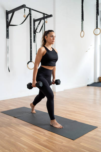 istock Woman on a mat exercising with dumbbells 2148938128