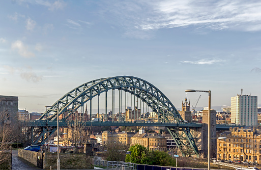 View of the Tyne bridge in the centre of Newcastle, UK.  People ca be seen on the promenade