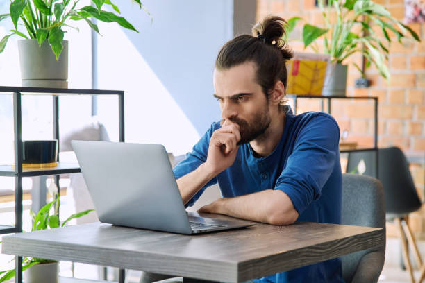 istock Young serious man working, studying using laptop sitting in coworking cafe 2148940881