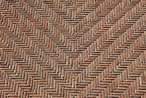 A wall with geometric motifs. Detail of a wall made of brick. Brown wall for background.
