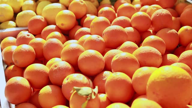 Lots of oranges close-up at farmers market, bunch of fresh oranges, orange is healthy fruit containing vitamin C.