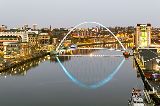 View across the river Tyne in the centre of Newcastle, UK.  Modern architecture can be seen and people can be seen on the promenade.