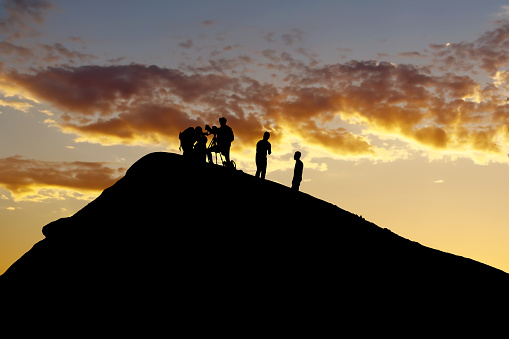 Silhouetted team conducting volcano research during picturesque sunset backdrop