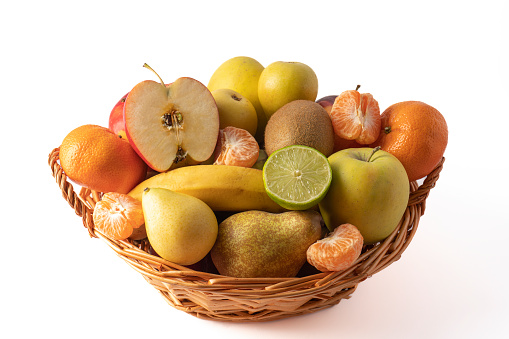 wicker basket with assorted fresh fruits, isolated on a white background
