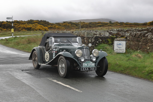 Caldbeck, England - April 13:  A 1938 Aston Martin 15/98 leaves Caldbeck, Cumbria on April 13, 2024.  The car is taking part in the Flying Scotsman Rally, a free public-event.