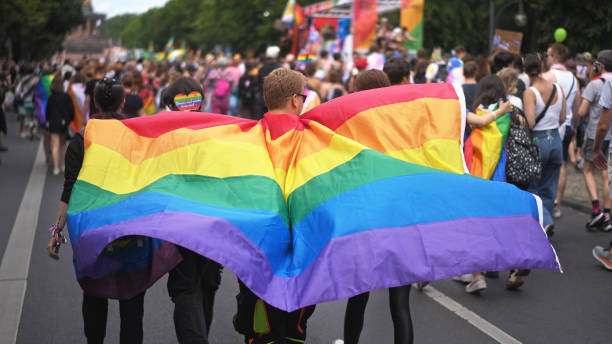 행복한 사람들은 게이 프라이드의 달을 축하합니다. lgbt 퍼레이드 축제. 레인보우 플래그 케이프. - flag gay man american culture rainbow 뉴스 사진 이미지