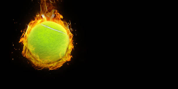 istock tennis ball on fire Isolated on a black background 2148947648