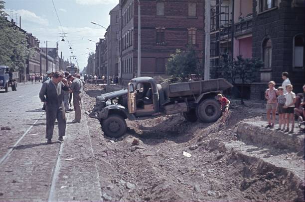 Nuremberg, Bayer, Germany, 1957. A truck is stuck in a construction ditch. Furthermore: the driver, construction workers and onlookers.