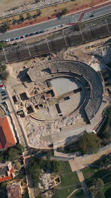 ancient Roman amphitheatre in Tarragona, Spain, old ruined coliseum, antique architecture, aerial drone view 4k, vertical video footage