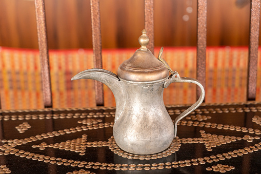 Dallah, metal pot for making Arabic coffee on ornamental table, Oman