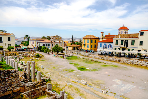 View of the essence of ancient splendor with a photo of the iconic archaeological site of Roman Agora, nestled in the charming Plaka district at the heart of Athens' historic center, Attica, Greece. Against a backdrop of cerulean skies, the remnants of this ancient market come to life, offering a glimpse into the bustling commerce of antiquity. Weathered columns and crumbling ruins stand as silent witnesses to centuries past, while sunlight dances upon ancient stones, casting a warm glow over the scene. Immerse yourself in the timeless allure of Roman Agora, where history and beauty converge in a captivating display of Athenian heritage.