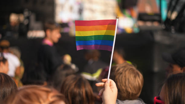 게이 사람은 작은 무지개 깃발을 흔든다. 사람들이 lgbt 프라이드 축제를 축하합니다. - flag gay man american culture rainbow 뉴스 사진 이미지