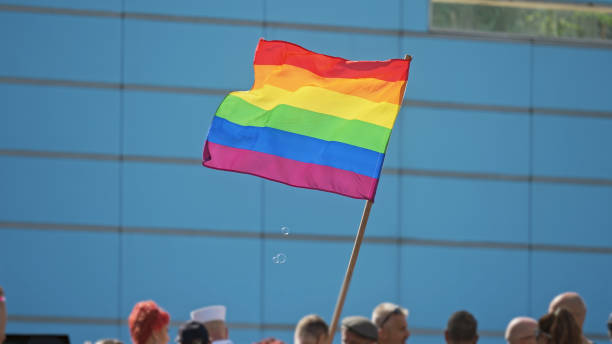 밝고 화려한 무지개 깃발을 흔들고 있습니다. 바람 흔들림 lgbt 상징입니다. 게이 프라이드 축제. - flag gay man american culture rainbow 뉴스 사진 이미지