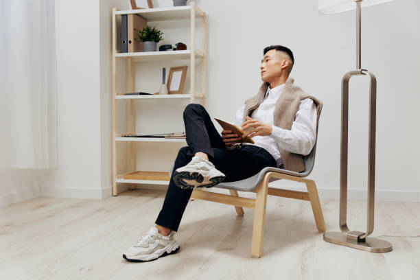 istock handsome man with a tablet sits in a chair communication interior 2148949656