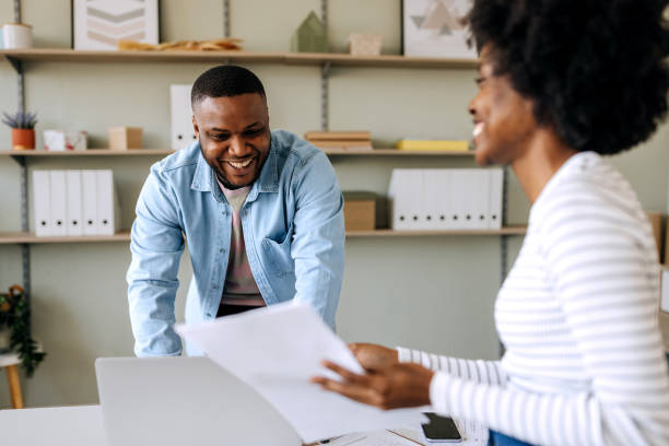 istock Two cheerful colleagues working at the office together 2148950297