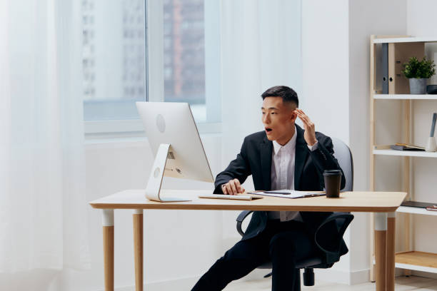 istock manager works at the computer glass of coffee emotion office technologies 2148950386