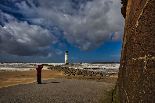 Perch Rock lighthouse tower with lone figure near beach