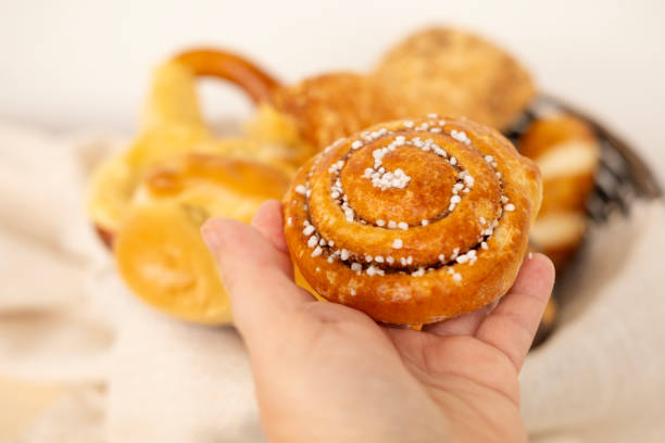 istock bun in female hand, Assorted blush-colored pastries, bread products, bakery, poppy seed rolls, indulgence and dietary discipline 2148951070