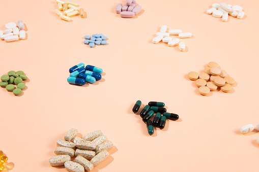 Medicine background with pills and tablets on pink background with copy space