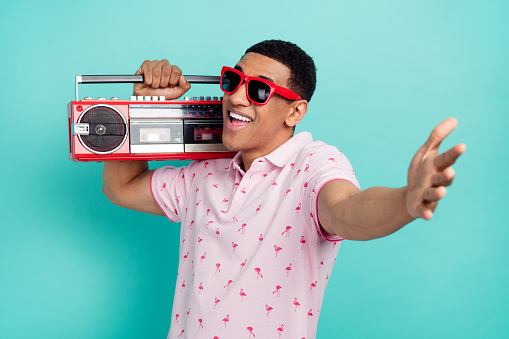 Photo of positive nice man carry boombox have fun arm welcome invite you isolated on teal color background.