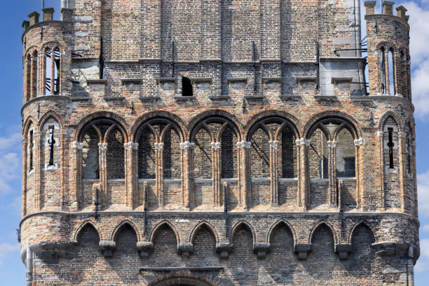 Bruges, Belgium - May 19, 2023: Details of facade of 13th century medieval  tower Belfort (Belfry). This clock tower is one of the recognizable symbols of the city