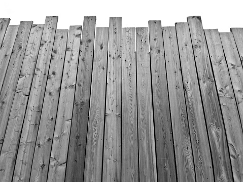 boarded lot with a palisade at the bottom. the top of the fence is jagged from boards like an unfinished fence. the sloppy look is intentional