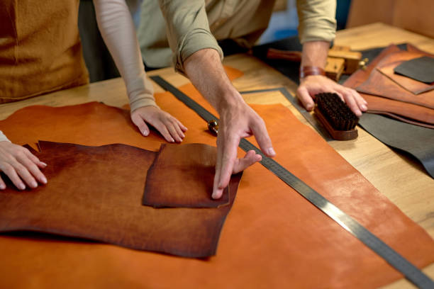 istock active craftsman shows to craftswoman where to cut leather 2148954404