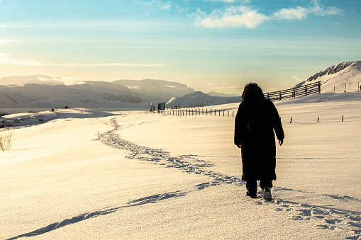 Young woman is walking on snow.
Hammerfest - Norway.