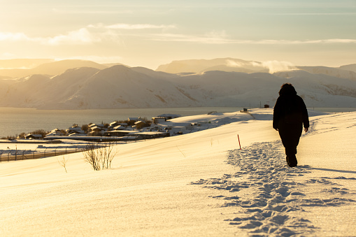 Young woman is walking on snow.
Hammerfest - Norway.