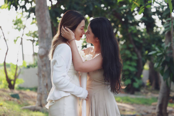 istock Two women sharing a tender moment in nature, touching each other's faces with affection. 2148955677