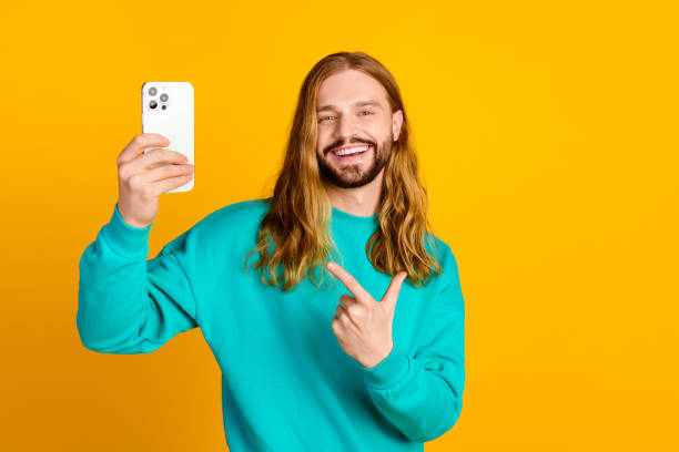 istock Photo of attractive man indicate finger hand hold apple iphone gadget empty space isolated on yellow color background 2148956228