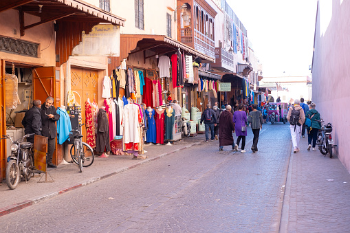 locals navigate labyrinthine alleyways, colorful attire and lively chatter painting captivating scene authentic African urban life in Marrakech, Morocco - January 7, 2024