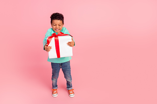 Full length photo of adorable little boy hold excited big giftbox wear trendy aquamarine garment isolated on pink color background.
