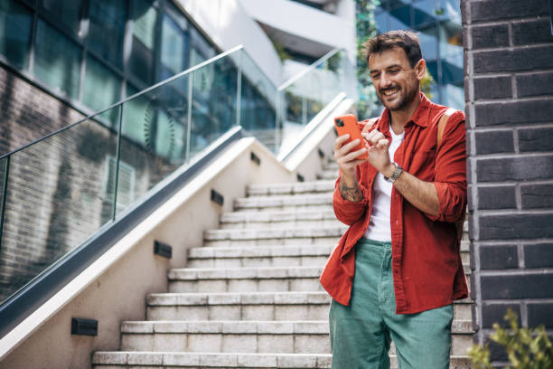 istock A man is standing on the stairs and using the phone. 2148957220