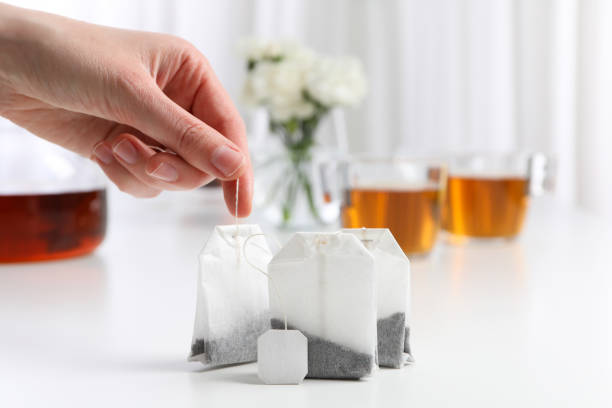 Couple of teabags standing on white background