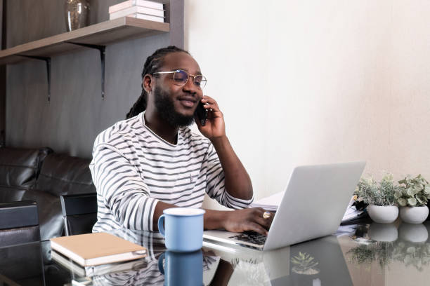 istock Young African American businessman spends his weekend working from home using his laptop in the living room. 2148957589