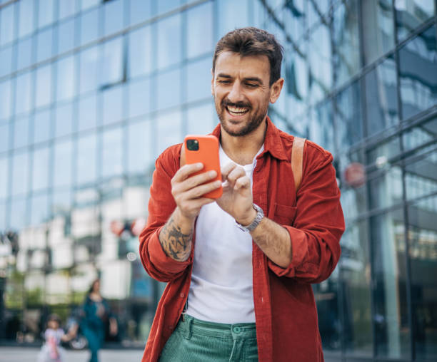 istock A relaxed man is walking down the street and using a smartphone. 2148958388