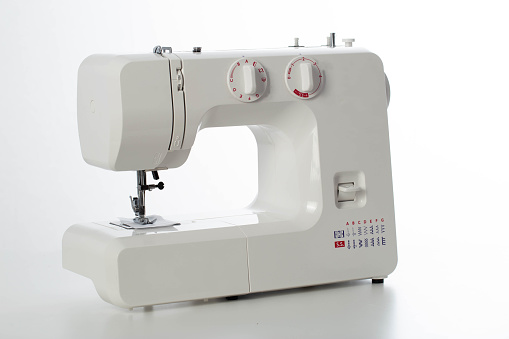 Automatic modern sewing machine with overlock on a white background, isolate. Studio concept.