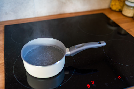 Boiling water in cooking pot on the kitchen stove