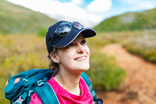 Portrait of mid adult woman in mountains during her vacation, trekking and enjoying the view