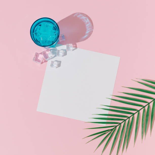 istock Creative summer layout made with cold refreshing drink, ice cubes, tropical palm leaf and paper card note copy space on pastel pink background. Minimal concept. Summertime party idea. Flat lay. 2148961132