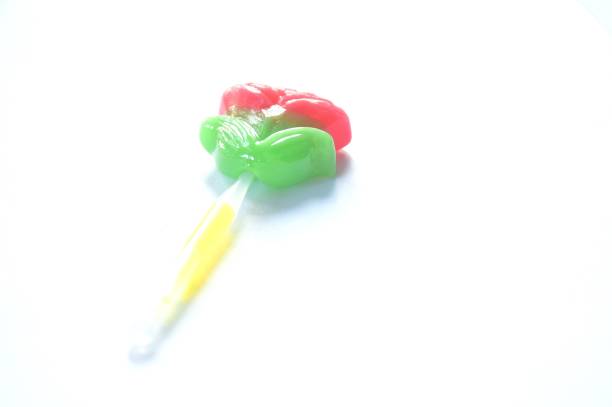 pink rose lollipop candy stabbing in plastic stick isolated on white background