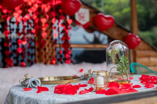 Dinner decoration in the hotel with many red balloons and paper heart on the food table