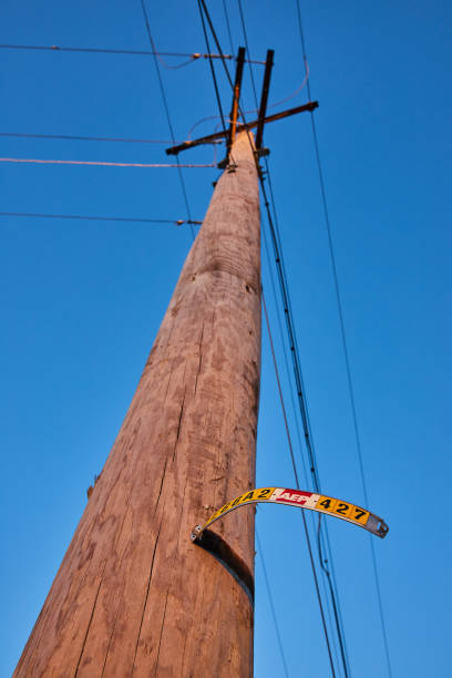 istock Weathered Utility Pole with Bent Street Sign, Blue Sky Background 2148961671