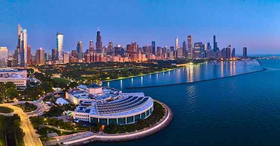 Vibrant Chicago skyline at dusk, featuring the iconic Willis Tower and Shedd Aquarium, captured by an aerial drone over Lake Michigan