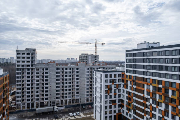 istock crane and a building under construction against a blue sky background 2148962108