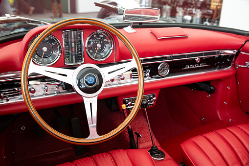 The steering wheel and details of the dashboard of a classic Mercedes-Benz 300SL.