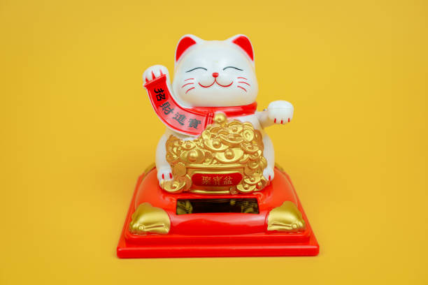 White cat figure beckoning, money fetching concept.